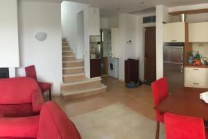 a kitchen and living room with red chairs and a table at Sun Village Villa 6 in Byala