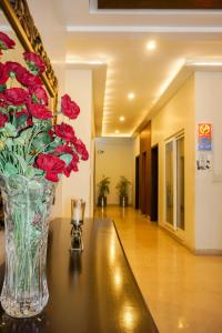 eine Vase voller roter Blumen auf einem Tisch in der Unterkunft City View Hotel & Restaurant in Lahore