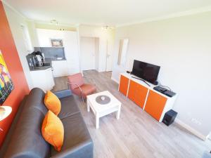 ein Wohnzimmer mit einem Sofa und einem TV in der Unterkunft Appartement 206 in Westerland