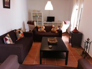 a living room with two couches and a coffee table at Casa en pueblo de montes de Málaga a 15km de playa in Almáchar