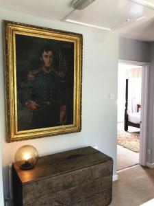 une peinture d'un homme en uniforme sur un mur dans l'établissement Owlpen Manor Cottages, à Uley