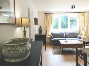 a living room with a couch and a table at Owlpen Manor Cottages in Uley