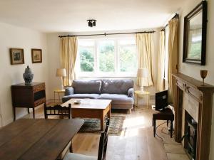 a living room with a couch and a table at Owlpen Manor Cottages in Uley