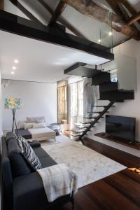 a living room with a couch and a staircase at D'Autor Apartments Alegria in Porto