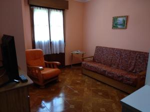 a living room with a couch and a chair at APARTAMENTOS RURALES PERNÚS in Colunga