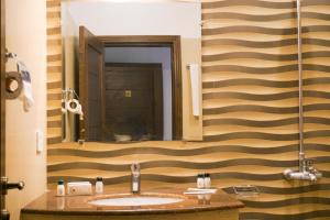 a bathroom with a sink and a large mirror at City View Hotel & Restaurant in Lahore