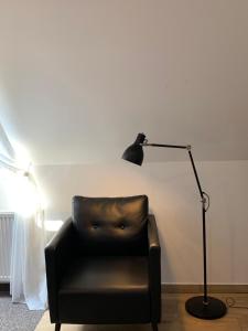 a black lamp sitting next to a leather chair at Villa Mona Lisa in Hévíz