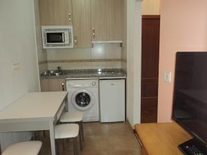 a small kitchen with a washing machine and a microwave at APARTAMENTOS RURALES PERNÚS in Colunga