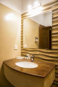uma casa de banho com um lavatório e um espelho grande em City View Hotel & Restaurant em Lahore