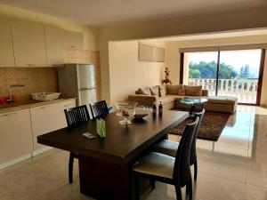 a kitchen and living room with a table and chairs at JOANNA SUNSET APTS Pomos in Pomos