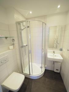 ein Bad mit einer Dusche, einem WC und einem Waschbecken in der Unterkunft Appartement 206 in Westerland