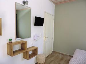 a room with a mirror and a bed and a chair at Villa Dafni Studios in Limenas