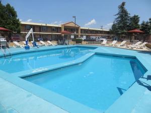 a swimming pool at a hotel with chairs and a building at TravelStar Inn & Suites in Colorado Springs