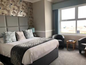 a bedroom with a large bed and a window at Camelia Hotel in Southend-on-Sea