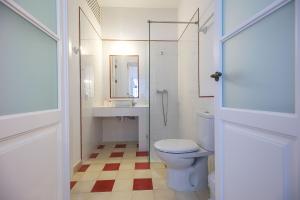 uma casa de banho com um WC, um lavatório e um espelho. em Casa Arco de las Monjas em Vejer de la Frontera