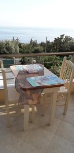 una mesa y sillas en un patio con vistas al océano en Dhori House Dhermi, en Dhërmi