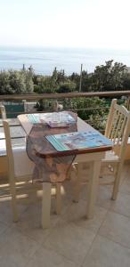 a table and chairs on a patio with a view of the ocean at Dhori House Dhermi in Dhërmi +79 photos