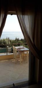 a table and chairs on a balcony with a view at Dhori House Dhermi in Dhërmi