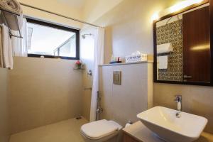 ein Badezimmer mit einem Waschbecken, einem WC und einem Spiegel in der Unterkunft The Xanadu, Coonoor in Coonoor