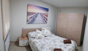 a bedroom with a bed and a painting on the wall at Apartamento Barajas. Aeropuerto/Ifema in Madrid