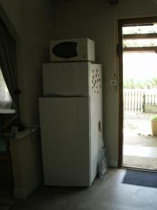a microwave sitting on top of a refrigerator at Gîte insolite de L'Escouriou in Villefranche-Sur-Cher