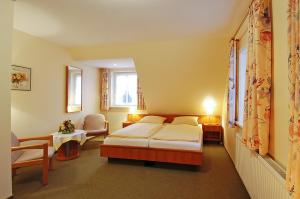 a bedroom with a bed and a chair in it at Undeloher Hof in Undeloh