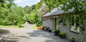 a brick house with a driveway next to a road at Drovers Retreat in Llandrindod Wells