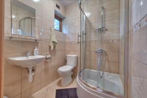 a bathroom with a toilet and a sink and a shower at DARMAT Domki Letniskowe in Stegna +37 photos