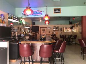 um bar com bancos de bar vermelhos num restaurante em Glacier Hotel em Valdez