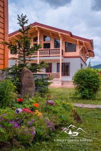 una casa con un jardín delante de ella en Apartments Chalet Girska Hatyna, en Vorokhta