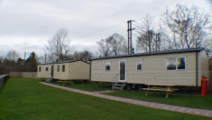Deux mobile homes assis sur une pelouse dans l'établissement Chapel View Caravans, à Embleton