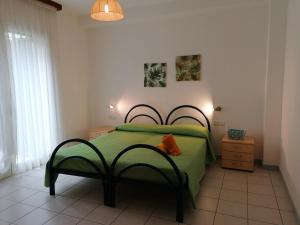 a bedroom with a green bed with a green blanket at Apartment Verde in Santa Maria Navarrese
