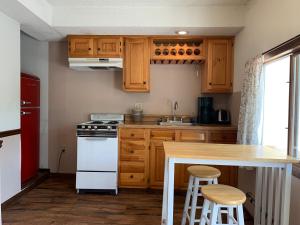 a kitchen with wooden cabinets and a white stove top oven at Green Acre Motel in Lake George