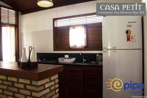 een keuken met een witte koelkast en een wastafel bij Pipa Casa Petit (Condomínio Pipa Natureza) in Pipa