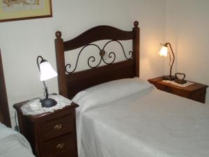 1 dormitorio con cama y mesita de noche con lámpara en HOTEL RURAL LA HUERTA, en Montejo de la Vega de la Serrezuela