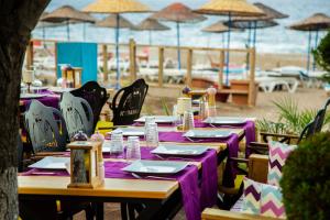 uma mesa com mesas e cadeiras roxas na praia em Kara Kedi Beach Bungalow em Cirali