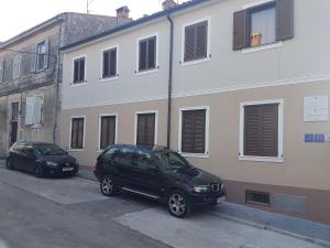 two cars parked in front of a building at Apartments Maletic in Pula