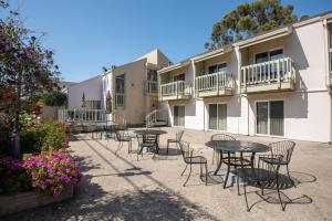 a courtyard with tables and chairs in front of a building at Cannery Row Inn in Monterey