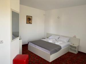 a bedroom with a bed and a red carpet at Casa Margo in Eforie Nord