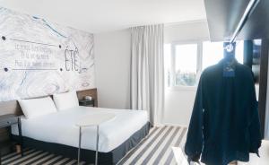 Un dormitorio con una cama y un maniquí en una habitación en ibis Styles Perpignan Canet En Roussillon, en Canet-en-Roussillon