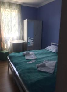 a bedroom with a green bed with towels on it at Lali in Tbilisi City
