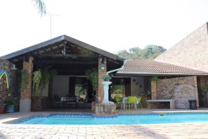a house with a swimming pool and a patio at A Pousada Guesthouse in Nelspruit