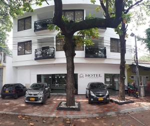 a hotel with three cars parked in front of it at Hotel Panama in Neiva