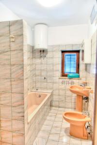 y baño con bañera, aseo y lavamanos. en Apartment Tijano, en Krnica