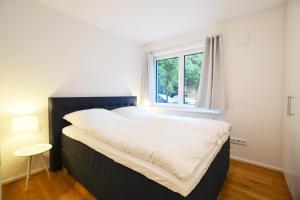 1 dormitorio con 1 cama grande y ventana en Modern apartment near downtown, en Múnich