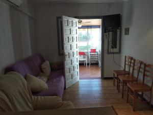 uma sala de estar com um sofá roxo e uma mesa em Apartamento Guillem em Riumar