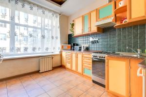 a kitchen with wooden cabinets and a large window at Apartment on Griboyedova 38 in Saint Petersburg