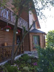 a wooden house with a balcony on the side of it at Берлога 2 in Mykulychyn