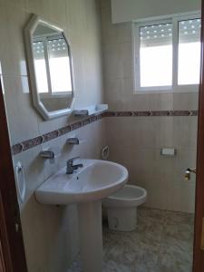 a bathroom with a sink and a toilet and a mirror at Hotel costa mar in Sanxenxo