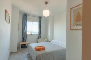 een kleine slaapkamer met een bed en een raam bij Livingtarifa Apartamento La Duna in Tarifa